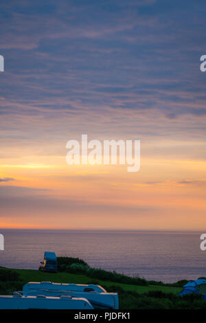 St. Ives, England -  May 2018 : Cars, tents and people on a camping site at dusk on the Cornish coast, Cornwall, UK Stock Photo