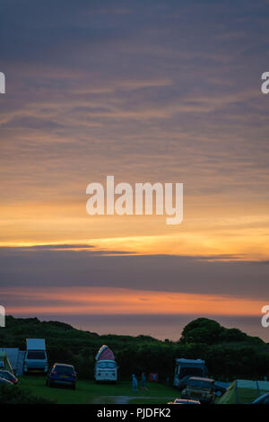 St. Ives, England -  May 2018 : Cars, tents and people on a camping site at dusk on the Cornish coast, Cornwall, UK Stock Photo