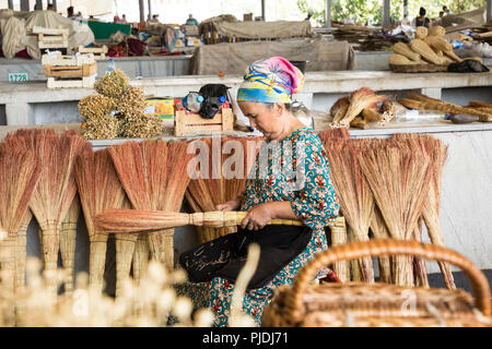 A pile of bamboo brooms in market for sale at Uzbekistan bazaar. Stock Photo