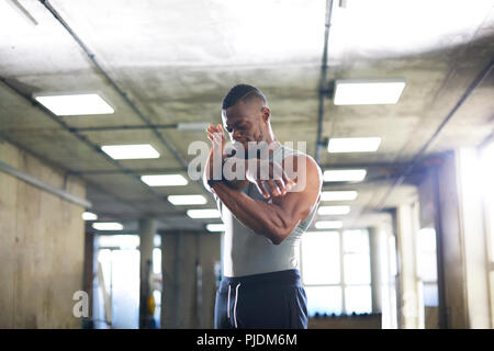 Man doing stretching exercise in gym Stock Photo