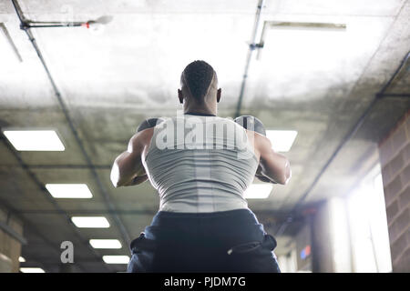 Man lifting kettlebells in gym Stock Photo