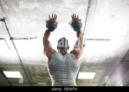 Man lifting kettlebells in gym Stock Photo