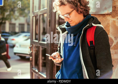 Man reading text message by door Stock Photo
