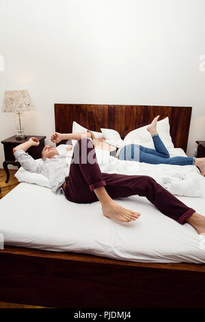 Young couple reclining on bed Stock Photo