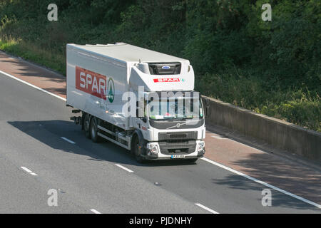 Spar supermarket Volvo Trucks, shipping freight, heavy haulage, lorry logistics delivery transport vehicles on the M6 at Lancaster, UK Stock Photo