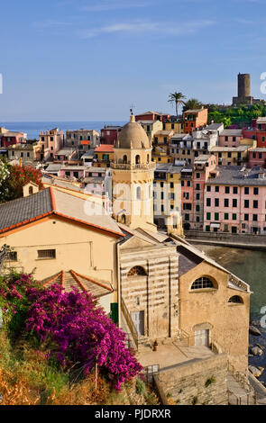 Italy, Liguria, Cinque Terre, Vernazza, view of the Church of Santa Margherita di Antiochia and Castello Doria with its Belforte Tower from high up on the Sentiero Azzurro or Blue Trail which is the famous hiking trail that links the 5 towns. Stock Photo