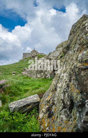 St. Ives, England -  June 2018 : Large rocks and boulders on a hillside with Saint Nicholas chapel on the hill in a background, Cornwall,  UK Stock Photo
