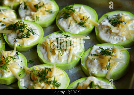 raw zucchini with cheese and dill on a baking sheet Stock Photo