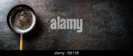Top of view empty old roast pan on dark concrete board. Stock Photo