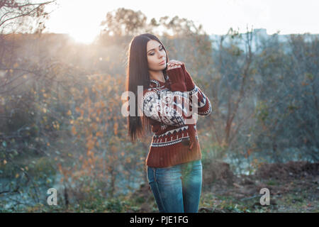 Pretty woman in the autumn before sunset. Stock Photo