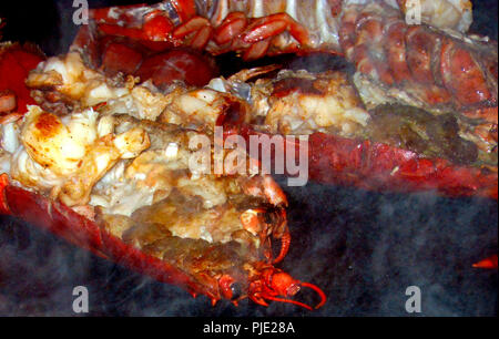 Lobster halves being fried on a large frying pan seasoned and ready to eat in a Japanese sushi restaurant in Amsterdam Stock Photo