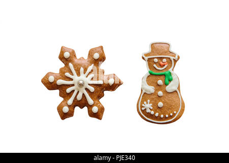 A set of traditional Christmas ginger cookies in the form of a decorated Christmas snowman and snowflakes isolated on white background. Stock Photo