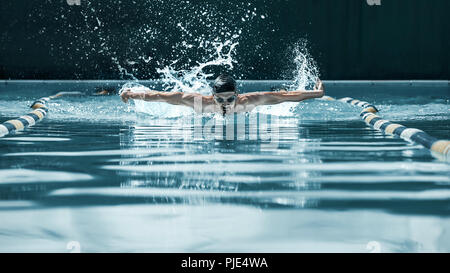 The dynamic and fit swimmer in cap breathing performing the