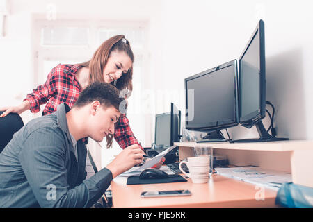Young colleagues in the office discussing the financial report and new business ideas and plans for better company advancement Stock Photo