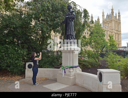 A woman takes a picture of the statue of suffragette leader Emmeline Pankhurst, who played a major role in the campaign to secure the vote for women, as Shadow Commons leader Valerie Vaz encouraged support for the campaign to keep the memorial in Victoria Tower Gardens, which border the Palace of Westminster in central London. Stock Photo