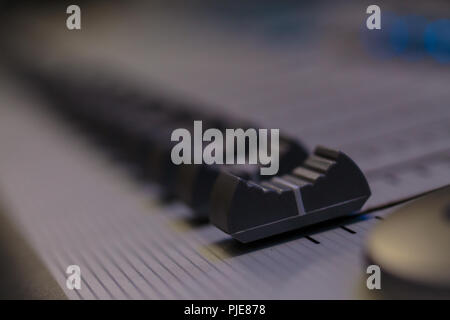 Professional Audio Sound Mixing Console Faders, white desk and black controller Faders Stock Photo