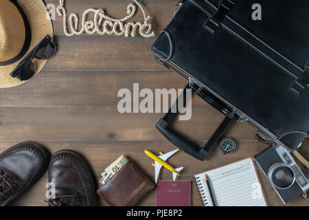 Old black vintage suitcase with welcome text and hipster accessories, copy space and travel concept Stock Photo