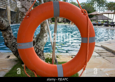 Marine lifebuoy or lifebelt on fence, near swimming pool Stock Photo