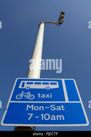 british blue and white road sign indicating a bus cycle and taxi lane with times of operation Stock Photo