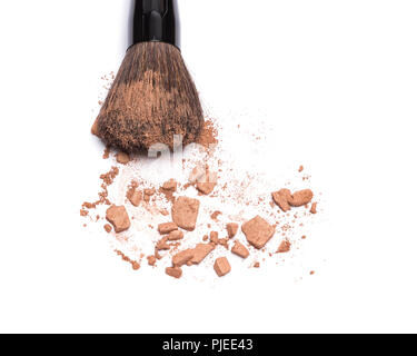 Close-up of makeup brush with crushed bronzing powder on white background. Bronzer for face contouring or creating tanned look Stock Photo