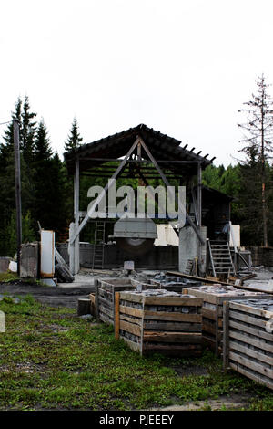 A large machine with a circular saw for cutting huge marble blanks and stones for making slabs next to the canyon. Industrial blanks of marble and stone. Circular Saw. Stock Photo