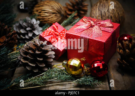 Red gift boxes and gold and red balls and pine cones decorate under christmas tree. Stock Photo