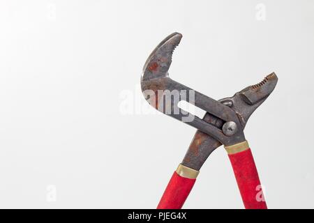 Rusty old Pipe Pliers with red rubber handles Stock Photo