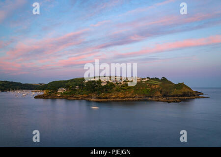 Pastel pink skys bathe the harbour in Fowey as another day draws to a close in Cornwall. Stock Photo