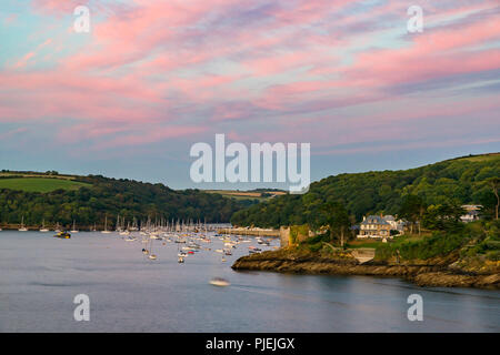 Pastel pink skys bathe the harbour in Fowey as another day draws to a close in Cornwall. Stock Photo