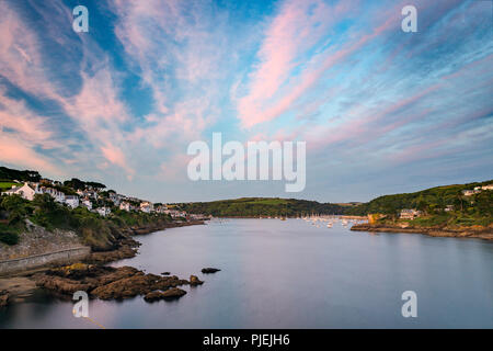 Pastel pink skys bathe the harbour in Fowey as another day draws to a close in Cornwall. Stock Photo