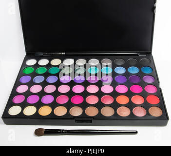 Circle patterns with rainbow colors of eye shadow make up used in the beauty industry by make up artists. Color pallet and brushes for make up applica Stock Photo