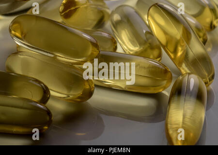 Gel Capsules close up filled with healthy fish oil us as vitamin supplements. Translucent medical capsules. Stock Photo