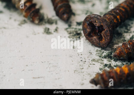 Close up selective focus of rusty screws. old steel bolts on grungy white wood background Stock Photo