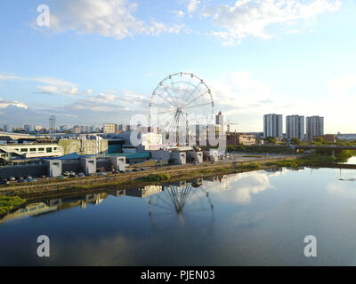Aerial drone view of embankment of Miass river in the city center with reflect of huge Ferris wheel on the water, sunny evening in the capital of Sout Stock Photo