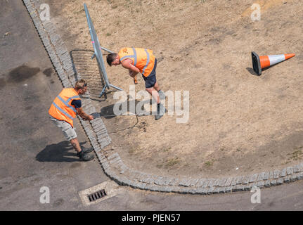 Rochester, England -  July 2018 : Two men working and setting up barriers during preparations for a festival Stock Photo