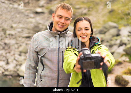 Beautiful couples takes a selfie with professional camera outdoor Stock Photo