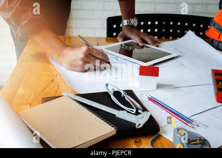 Architect or engineer using pen working on blueprint, architectural concept Stock Photo