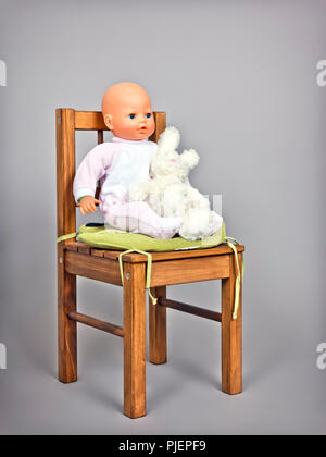 An image of a baby puppet on a chair Stock Photo