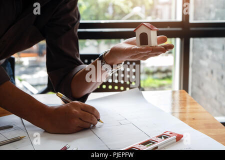 Architect or engineer using pen working on blueprint, architectural concept Stock Photo