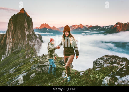 Happy Couple holding hands traveling together hiking in Norway healthy lifestyle concept active vacations outdoor Segla mountain sunset landscape Stock Photo