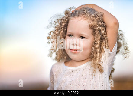 Outdoor portrait of a smiling little girl. Positive emotion concept. Stock Photo