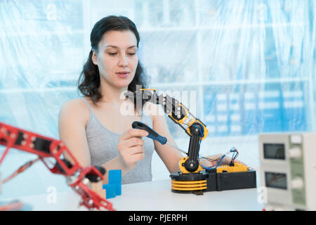 girl in a University laboratory is experimenting with a robot Stock Photo