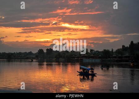 September 6, 2018 - Srinagar, J&K, India - A Kashmiri boatman seen ferrying tourists in his traditional boat during sunset at the Dal Lake in Kashmir.Nestled in the Himalayan Mountains and known for its beautiful lakes and saucer-shaped valleys, the Indian portion of Kashmir, is also one of the most militarized places on earth. Credit: Saqib Majeed/SOPA Images/ZUMA Wire/Alamy Live News Stock Photo