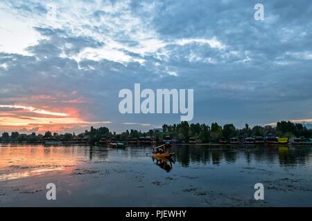 September 6, 2018 - Srinagar, J&K, India - A Kashmiri fisherman seen rowing his traditional boat during sunset at the Dal Lake in Kashmir.Nestled in the Himalayan Mountains and known for its beautiful lakes and saucer-shaped valleys, the Indian portion of Kashmir, is also one of the most militarized places on earth. Credit: Saqib Majeed/SOPA Images/ZUMA Wire/Alamy Live News Stock Photo