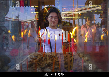 Kuala Lumpur, Klang, Malaysia. 26th Aug, 2018. A lady seen burning a joss stick before making an offerings during the hungry ghost festival at a temple in Klang.Hungry ghost festival were celebrated at Malaysia on the 7th month of Chinese calendar by the Buddhist, Taoist and also since the Chinese ancient religion has believe the gate of hell will be open for the hungry ghost to seek food an entertainment on the world. According to their understanding the hungry ghost can emerge from neglect or desertion of ancestor and also from the violent and unhappy death. Usually the devotee families Stock Photo