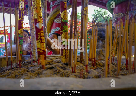 Kuala Lumpur, Klang, Malaysia. 26th Aug, 2018. A couple of devotee's seen placing a big joss sticks during the hungry ghost festival at a temple in Klang.Hungry ghost festival were celebrated at Malaysia on the 7th month of Chinese calendar by the Buddhist, Taoist and also since the Chinese ancient religion has believe the gate of hell will be open for the hungry ghost to seek food an entertainment on the world. According to their understanding the hungry ghost can emerge from neglect or desertion of ancestor and also from the violent and unhappy death. Usually the devotee families will o Stock Photo