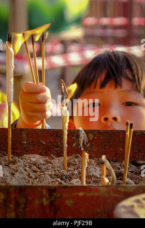 Kuala Lumpur, Klang, Malaysia. 26th Aug, 2018. A little boy seen lighting up a joss stick during the hungry ghost festival at a temple in Klang.Hungry ghost festival were celebrated at Malaysia on the 7th month of Chinese calendar by the Buddhist, Taoist and also since the Chinese ancient religion has believe the gate of hell will be open for the hungry ghost to seek food an entertainment on the world. According to their understanding the hungry ghost can emerge from neglect or desertion of ancestor and also from the violent and unhappy death. Usually the devotee families will offer praye Stock Photo