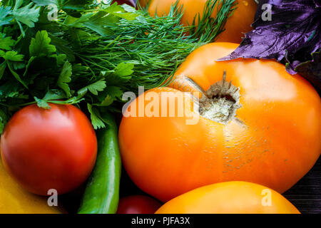 Colorful fresh vegetables background.  Ripe multicolor vegetables close-up on wooden table. Tomatoes, zucchini, hot  pepper and herbs Stock Photo