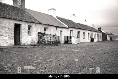 1950s, a row of traditional single-storey terraced cottages, Hebrides, Western Isles, Scotland, UK. These basic stone-built dwellings would have been homes to crofters, those working the land. Stock Photo