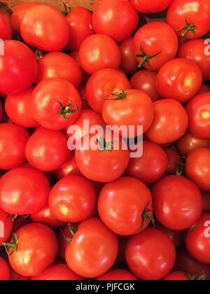 A full frame background image of ripe, fresh organically produced red tomatoes on a market stall Stock Photo